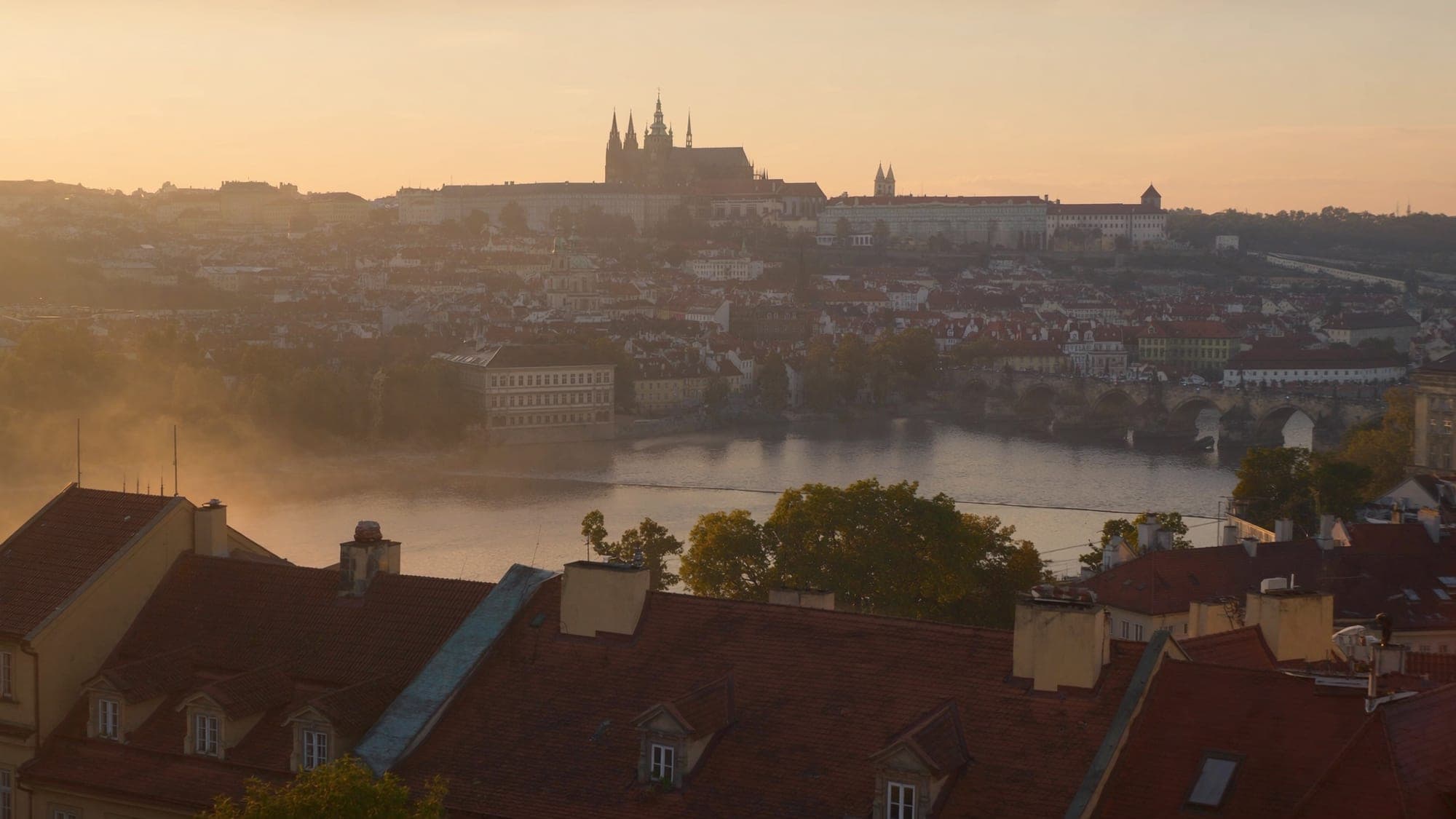 Rooftops of Prague's Malá Strana and Charles Bridge in early morning light
