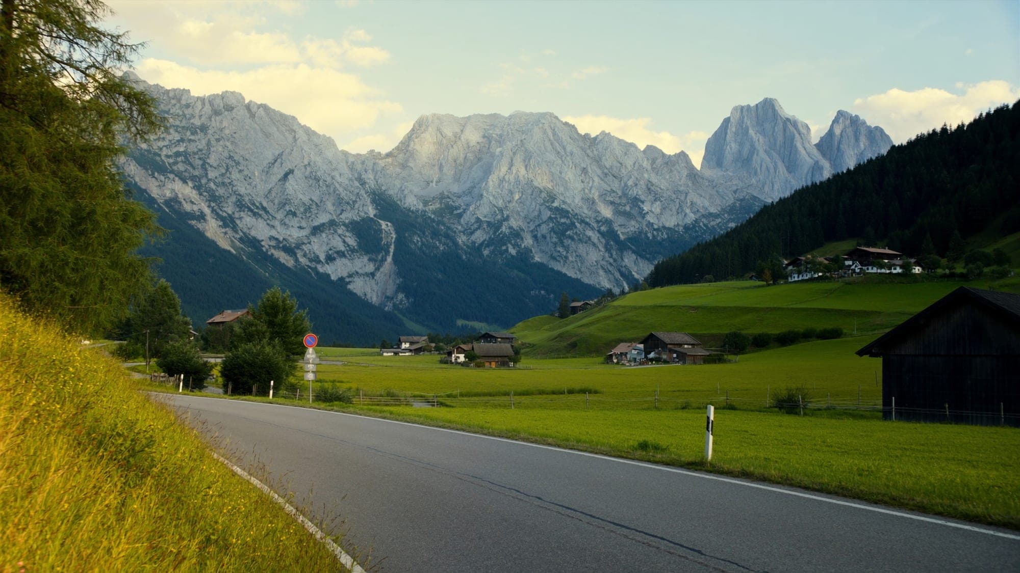 Country road through a Tyrolean valley with the Wilder Kaiser range in golden evening light